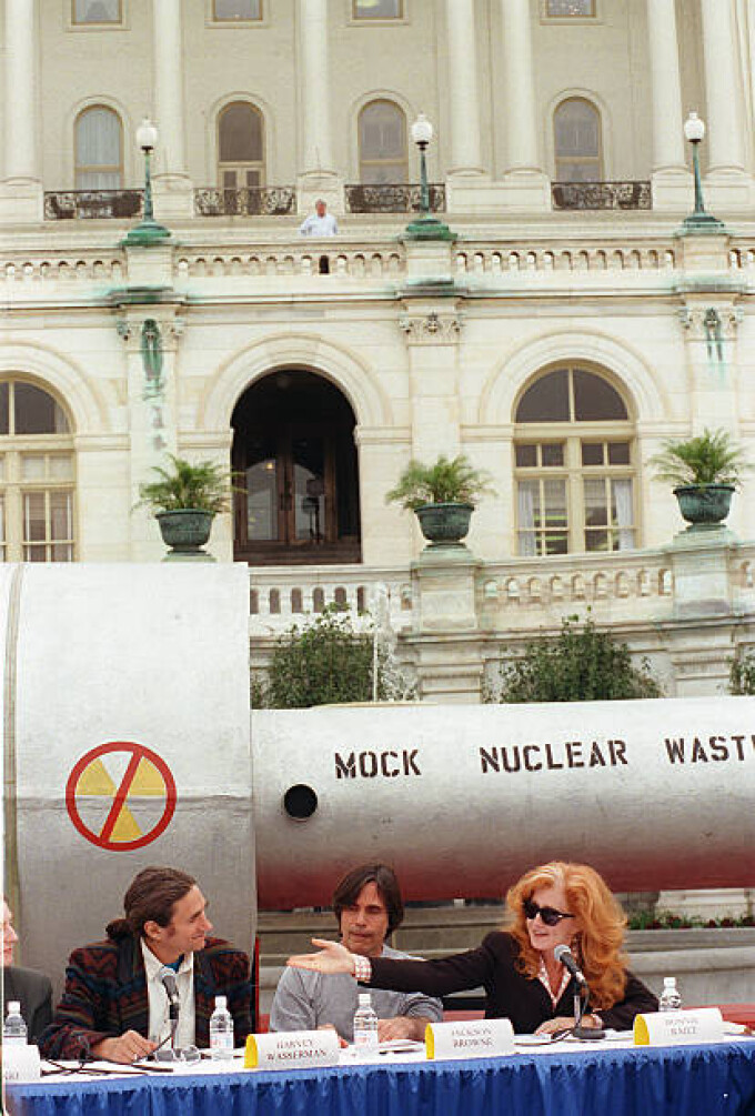 Performing artist Bonnie Raitt, right, motions toward Harvey Wasserman of Greenpeace, left, as performing artist Jackson Browne looks on at a press conference on the West Terrace of the Capitol in opposition to H.R. 1270, the Nuclear Waste Policy Act of 1997, which would allow for the transfer of radioactive waste to Yucca Mountain, Nevada. Behind them is a mock nuclear waste cask. Also attending were Nevada Democrat Sens. Harry Reid and Richard Bryan. Sept.24, 1997