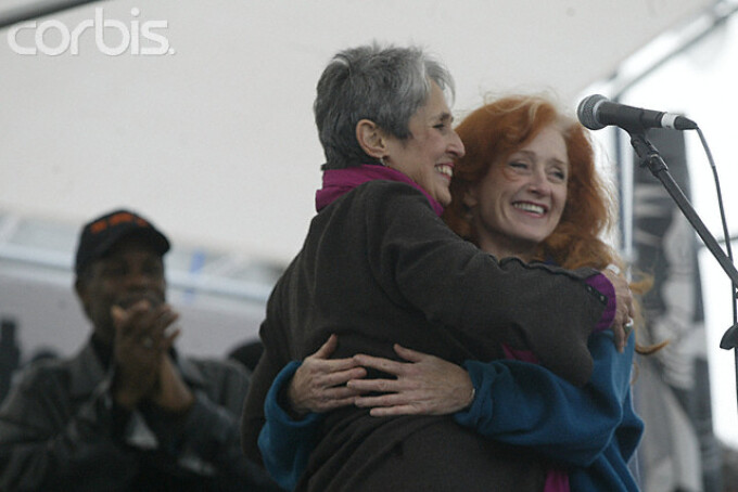 Bonnie Raitt (R) and Joan Baez (C) hug after their duet while Danny Glover (L) applauds from behind them onstage during a protest against the possible American invasion of Iraq. San Francisco, California, USA - 16 Feb 2003