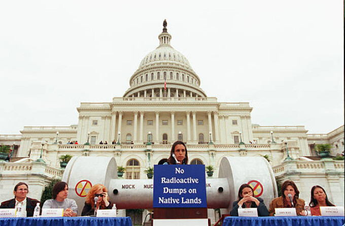 Left to right: Harvey Wasserman, of Greenpeace, performing artists Jackson Browne and Bonnie Raitt, Winona LaDuke, of the Seventh Generation Fund, Native American poet and performing artist John Trudell, Amy Ray, of the music group "Indigo Girls," and Virginia Sanchez, of Honor the Earth, sponsor of the Indigo Girls' fundraising tour, at a press conference on the West Terrace of the Capitol in opposition to H.R. 1270, the Nuclear Waste Policy Act of 1997, which would allow for the transfer of radioactive waste to Yucca Mountain, Nevada. Behind them is a mock nuclear waste cask. Sept.24, 1997